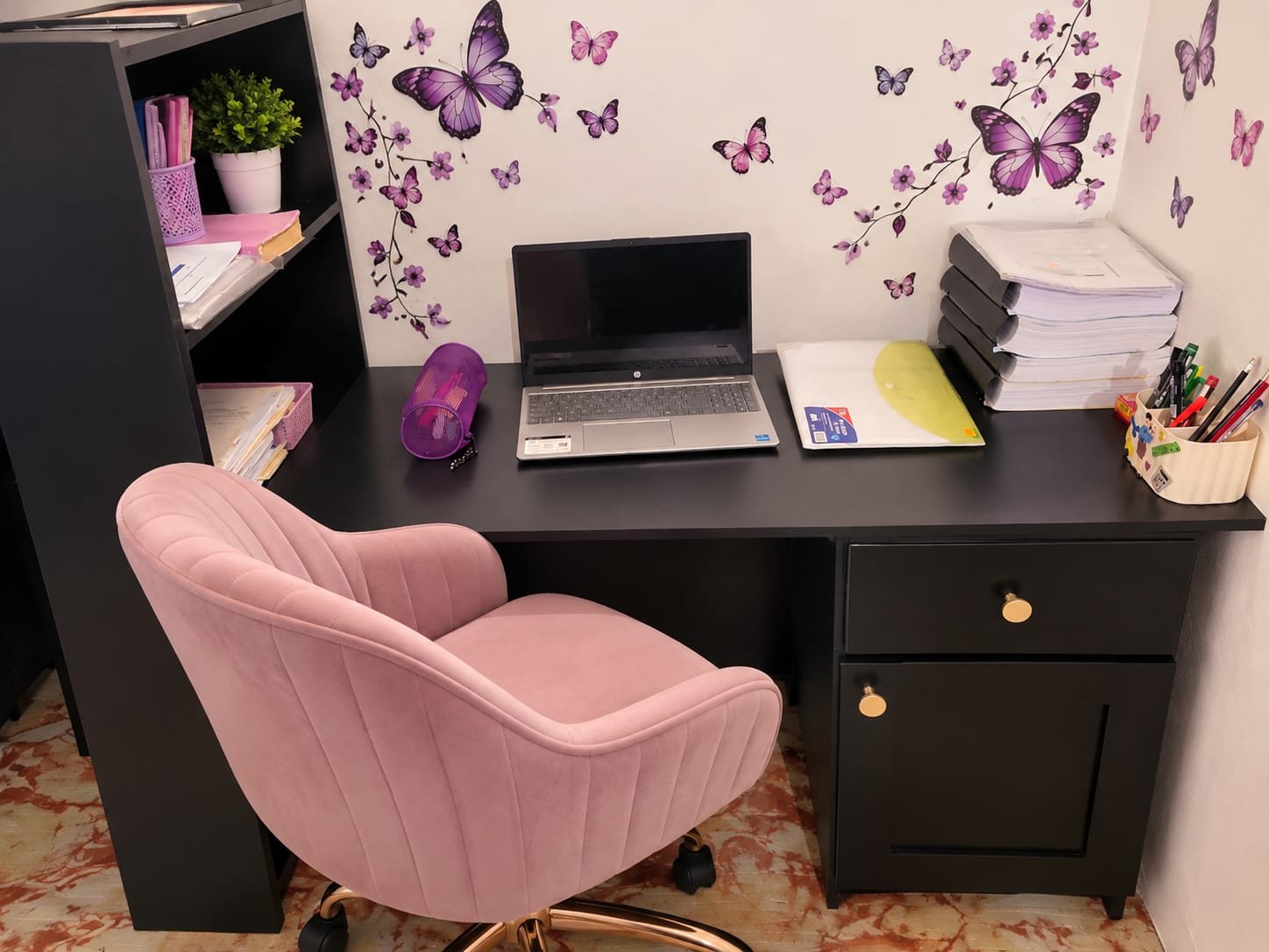 Custom black home office desk with shelving, drawers, and a pink accent chair in use