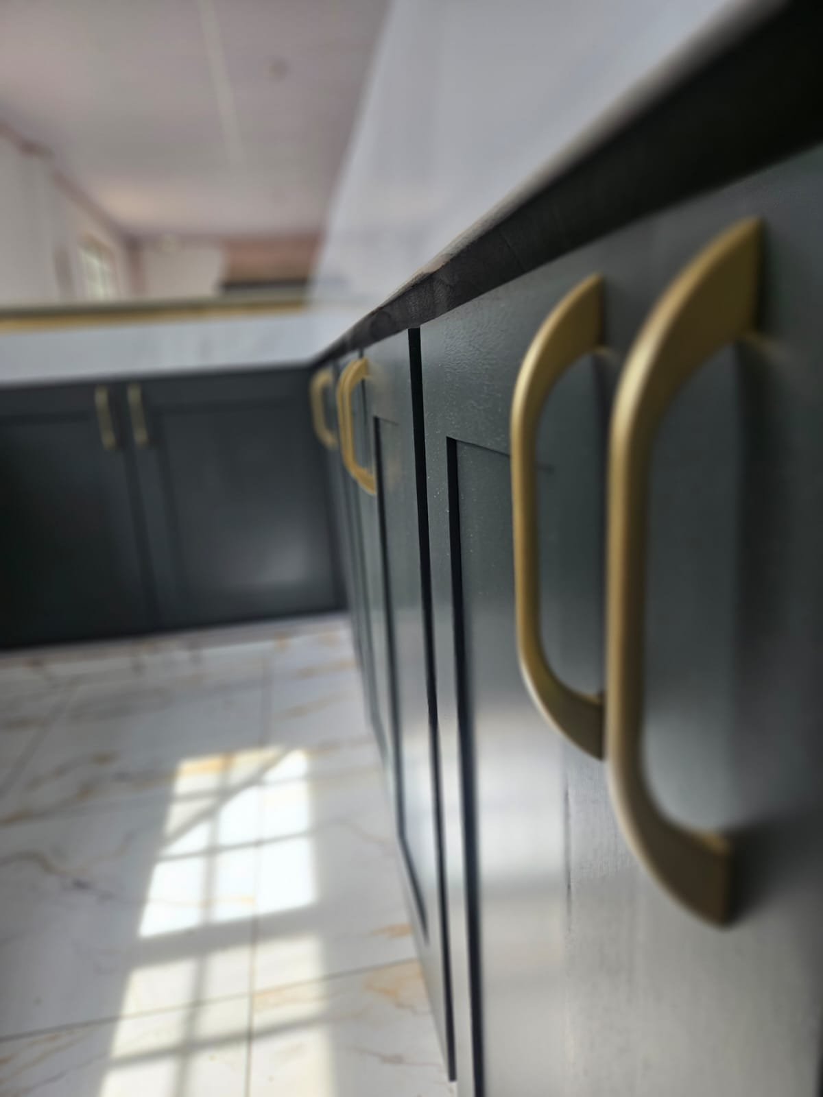Close-up of matte charcoal cabinet doors with brushed brass handles